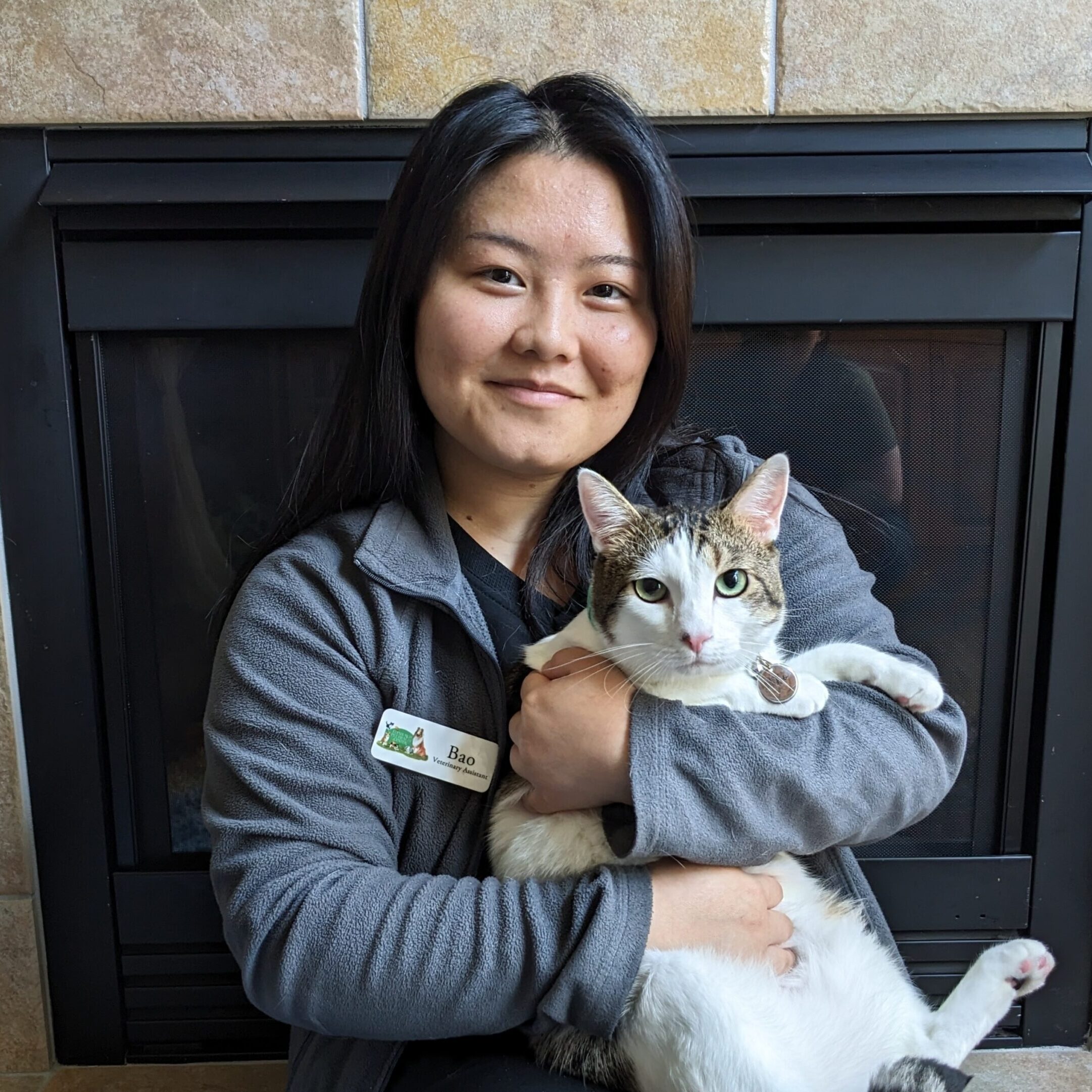 Woman smiling holding a calico cat